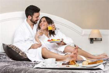 A photo of a couple enjoying their breakfast in their hotel room